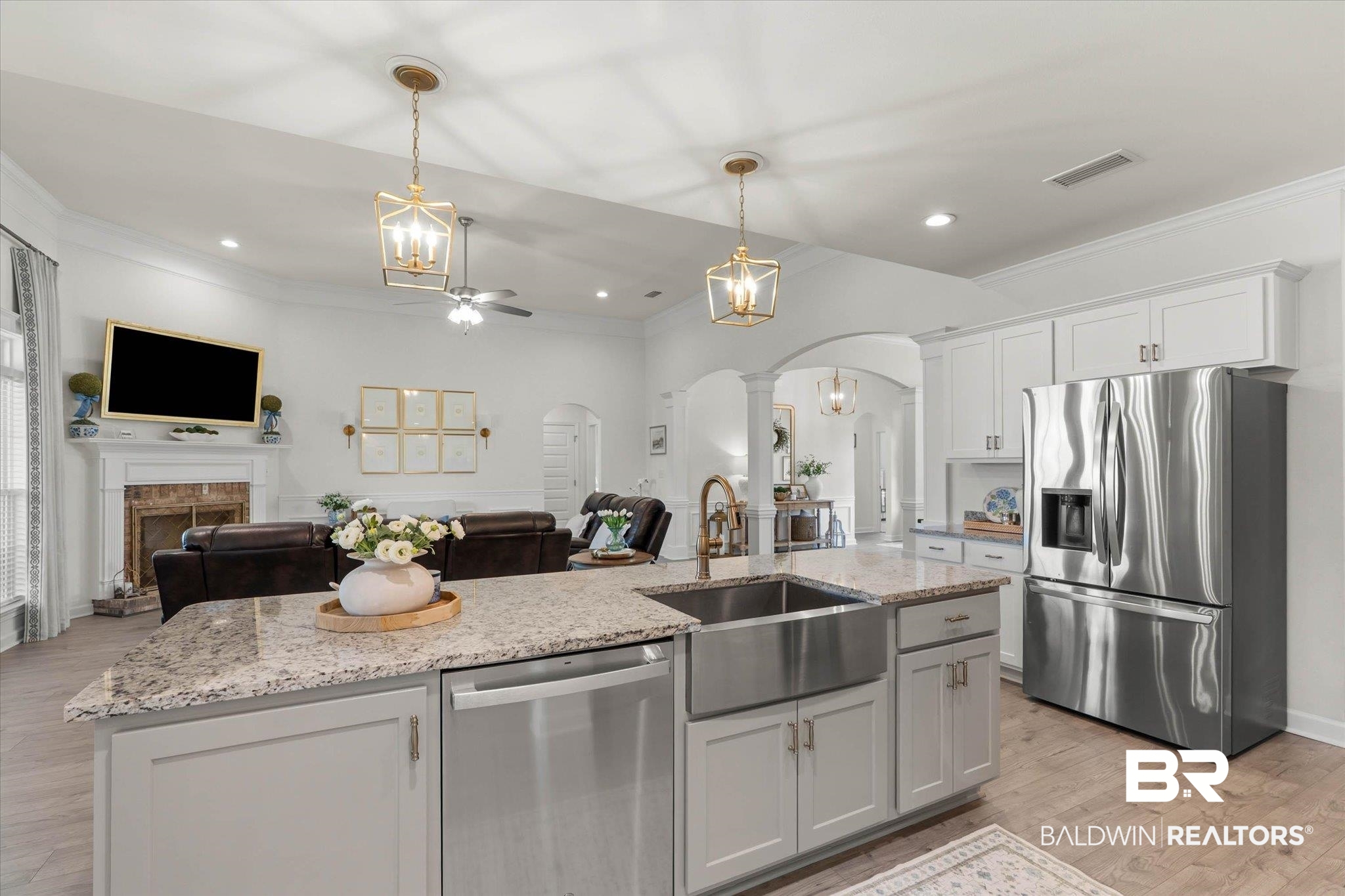 9074 Moses Way Theodore, AL 36582 - Photo 18 of 52 Kitchen island featuring a farmhouse sink, granite countertop, and stainless steel dishwasher, illuminated by two gold-finish pendant lights