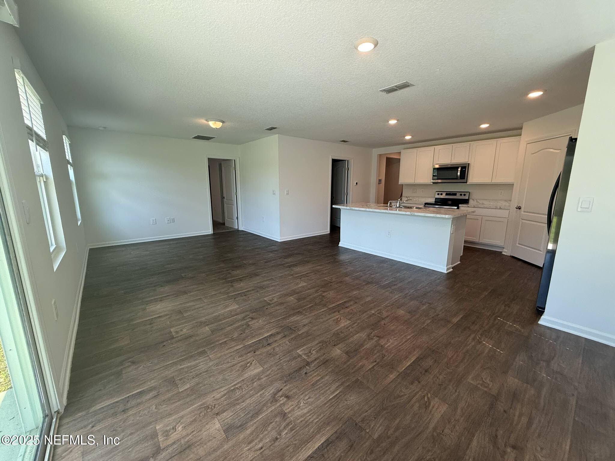 65183 Forest Glen Lane Yulee, FL 32097 - Photo 28 of 44 a view of kitchen with kitchen island granite countertop refrigerator stove microwave and cabinets