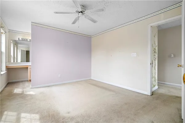 an empty room with a ceiling fan and a window