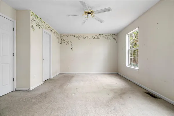 a view of a big room with windows and chandelier fan