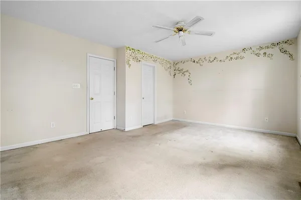 an empty room with a ceiling fan and a window