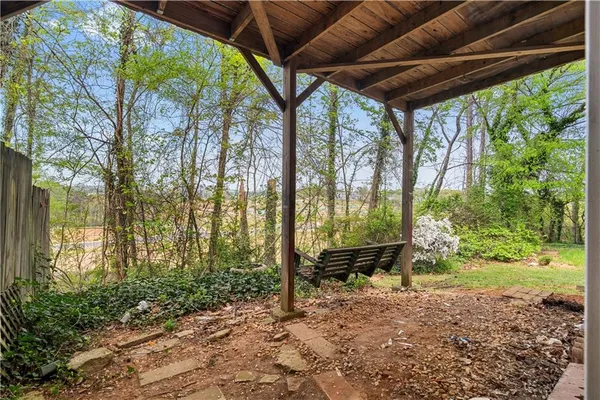 a backyard of a house with trees and outdoor seating