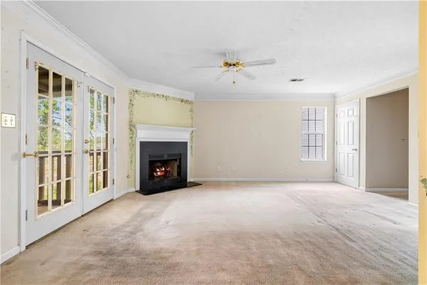 a view of an empty room with a fireplace and a window