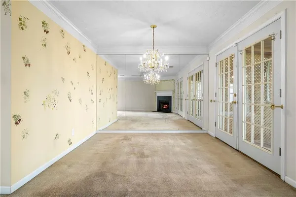 a view of a hallway with windows and chandelier