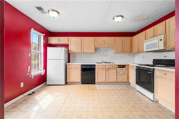 a kitchen with stainless steel appliances granite countertop a stove a sink and a refrigerator