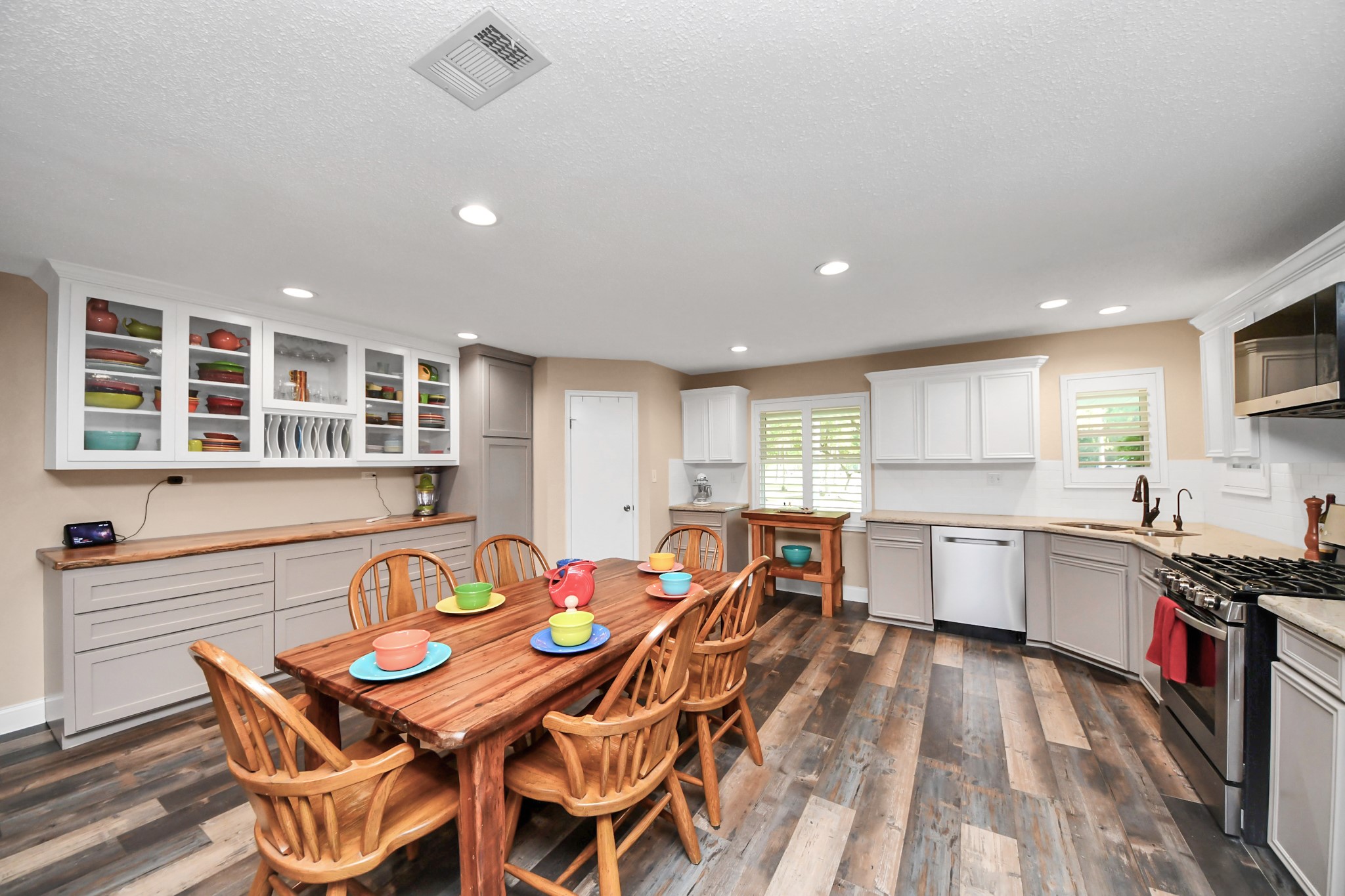 20202 Deer Run Road Damon, TX 77430 - Photo 22 of 45 a kitchen with stainless steel appliances granite countertop a stove a sink a dining table and chairs with wooden floor