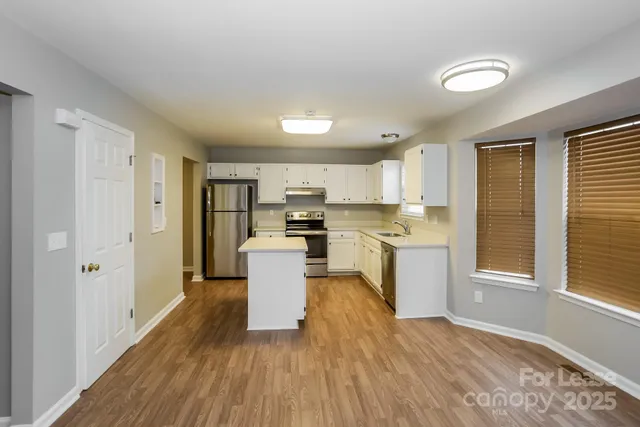a kitchen with a refrigerator and white cabinets