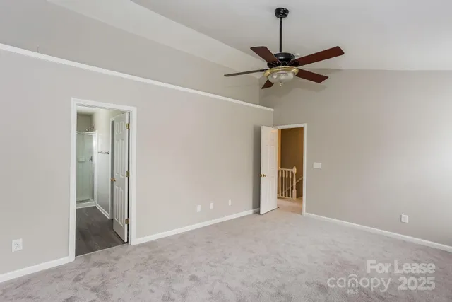 a view of an empty room and chandelier fan