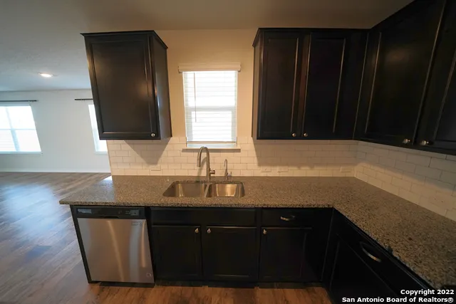 a kitchen with a sink a window and cabinets
