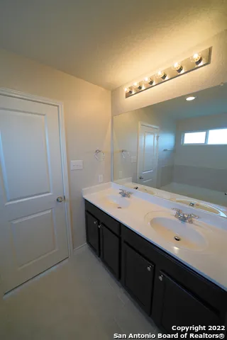 a bathroom with a double vanity sink and mirror