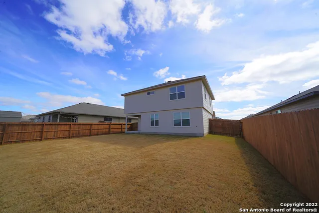 a view of a house with a big yard and large tree
