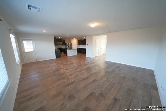 an empty room with wooden floor and fireplace