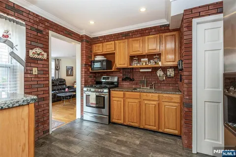 a kitchen with stainless steel appliances granite countertop a refrigerator a stove and a sink