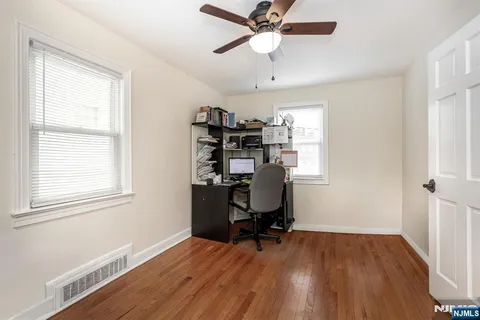 a view of a workspace with furniture and a window