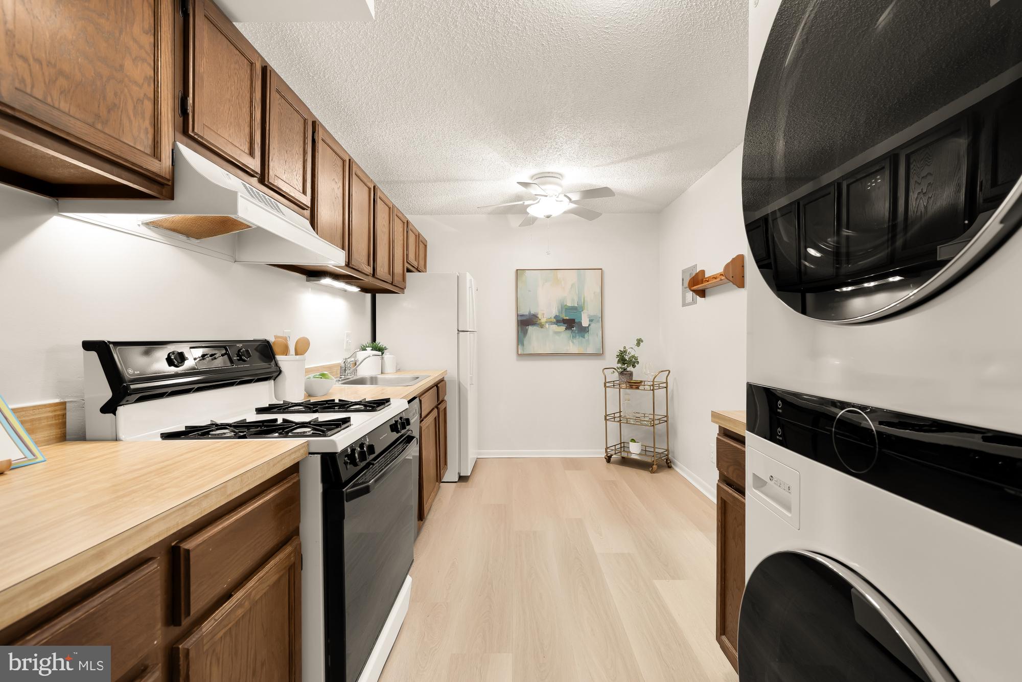 11833 Shire Court, Unit 21B Reston, VA 20191 - Photo 16 of 37 a kitchen with stainless steel appliances a stove a sink and a microwave