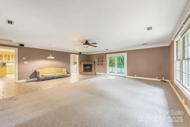 a view of an empty room with window and chandelier