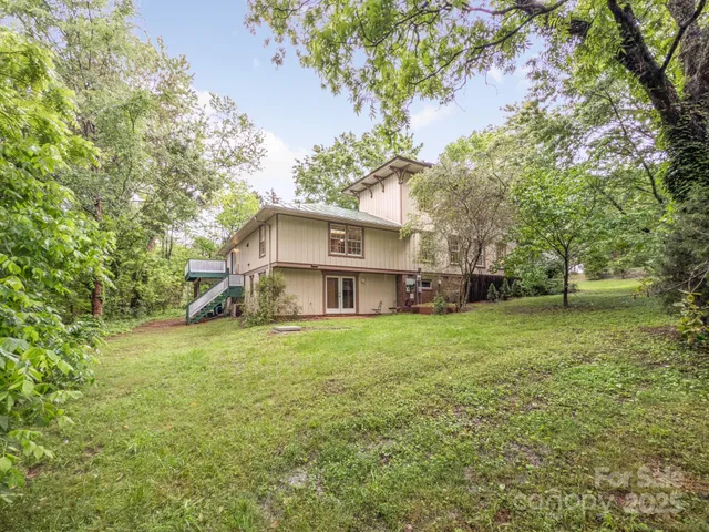 a front view of house with yard and trees in the background