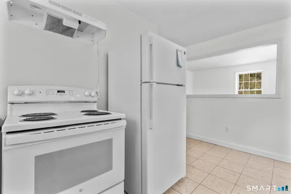a kitchen with white cabinets and white appliances