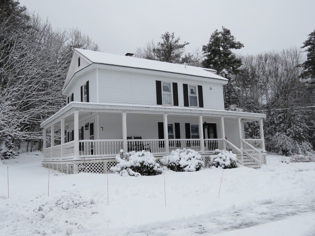 a front view of a house with a yard covered in snow