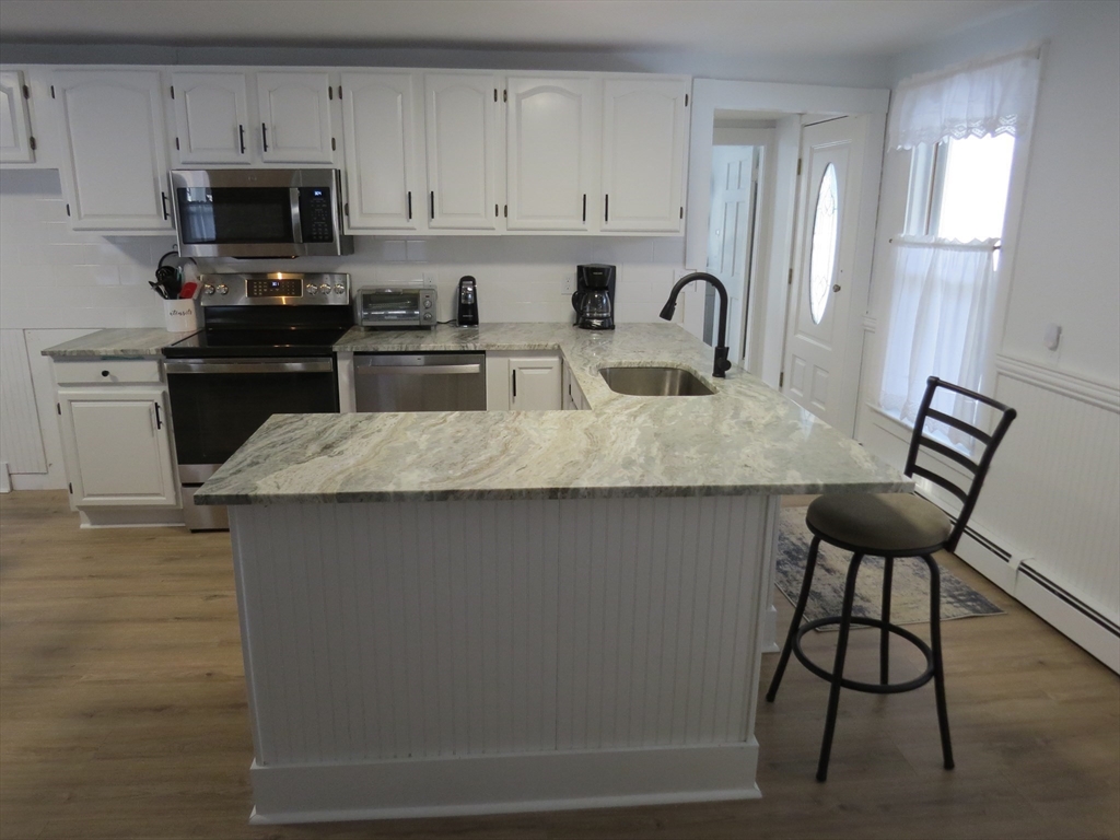 7 Maple Place Winchendon, MA 01475 - Photo 4 of 22 a kitchen with granite countertop a stove a sink and a microwave