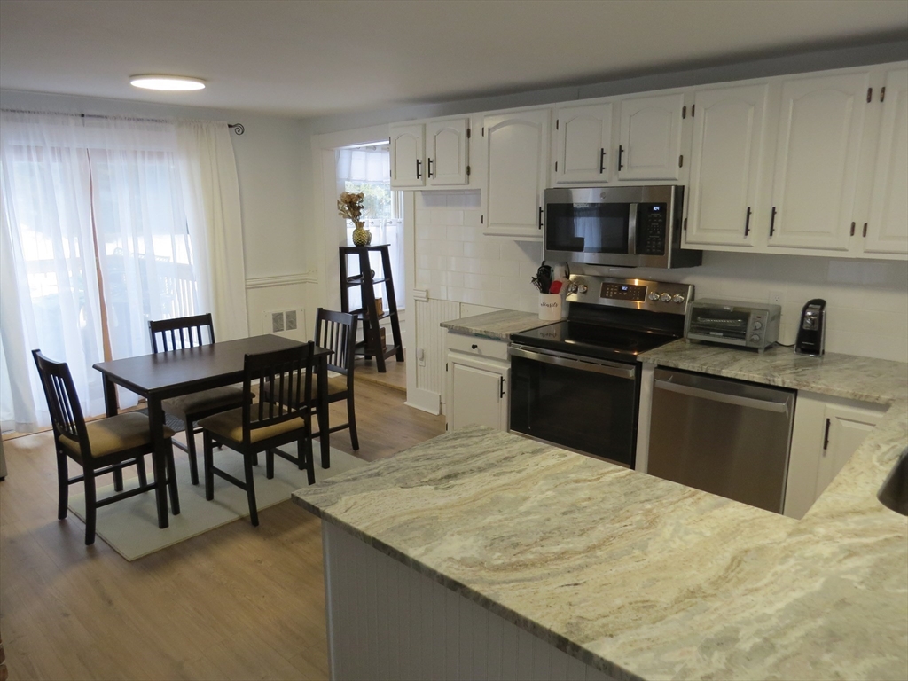7 Maple Place Winchendon, MA 01475 - Photo 5 of 22 a kitchen with stainless steel appliances granite countertop a stove top oven a sink a dining table and chairs
