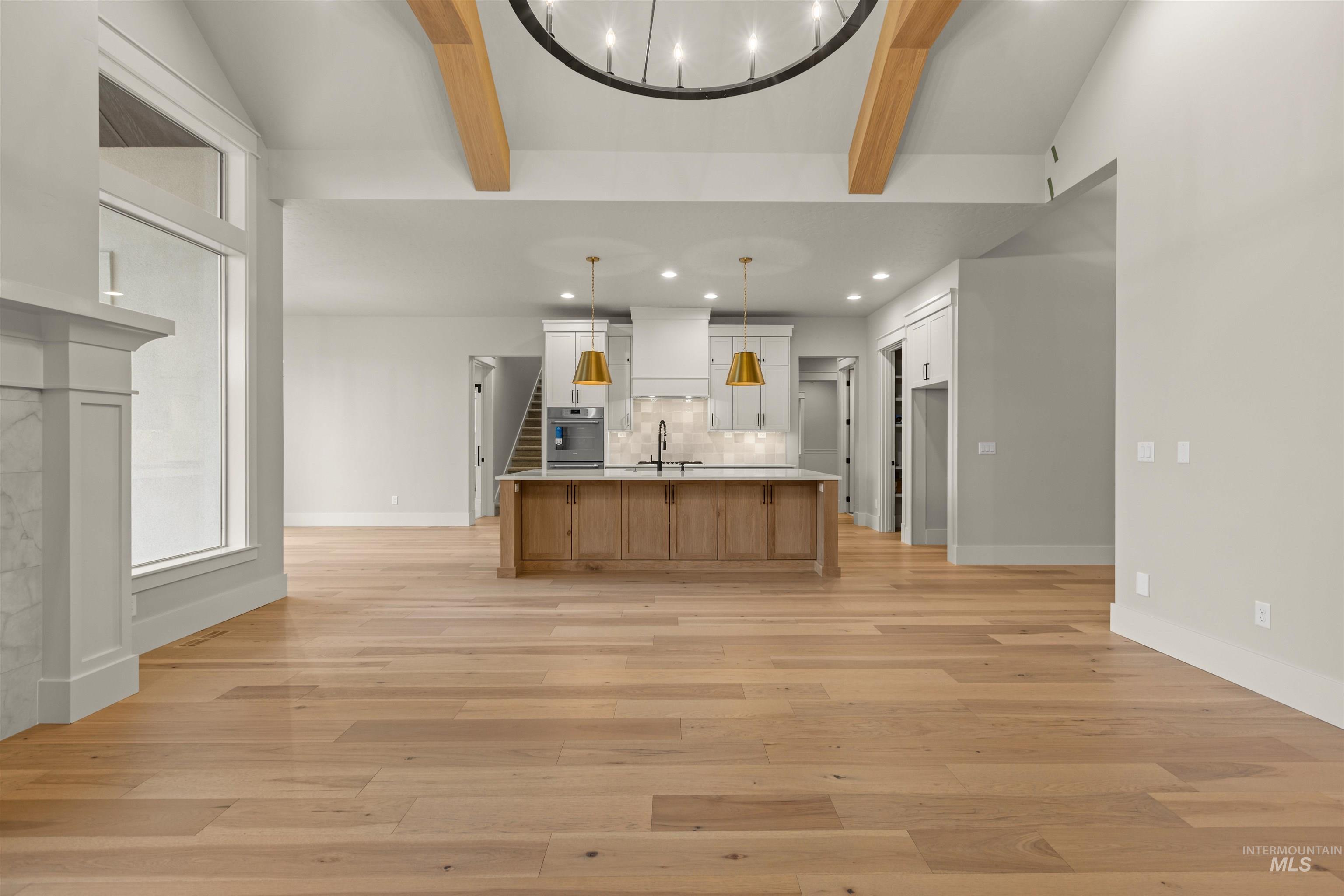 6844 South Messner Way Meridian, ID 83642 - Photo 49 of 49 Kitchen with beam ceiling, open floor plan, a large island, light wood-type flooring, and brown cabinetry