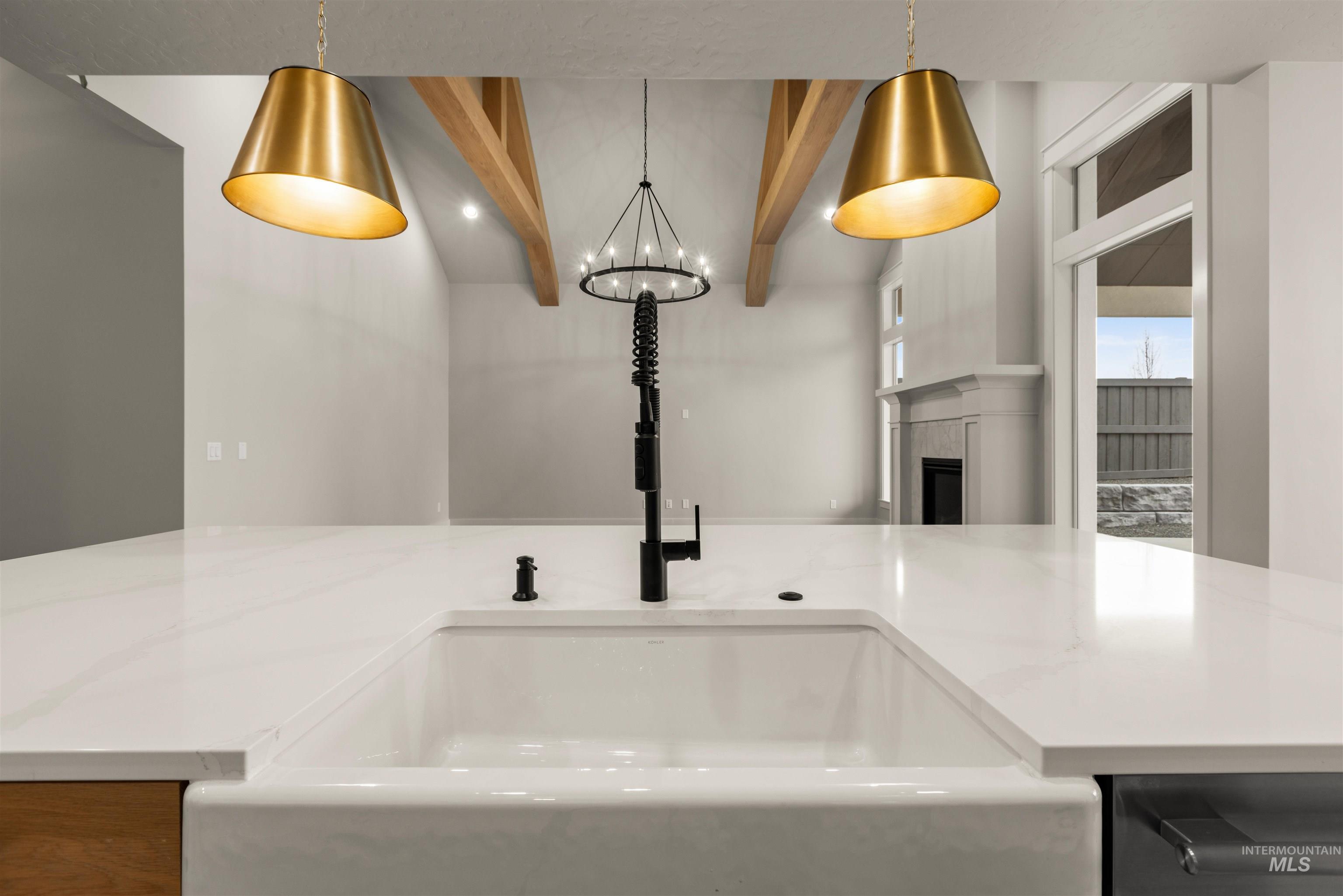 6844 South Messner Way Meridian, ID 83642 - Photo 16 of 49 Kitchen view of beam ceiling, a fireplace, light stone counters, pendant lighting, and a chandelier