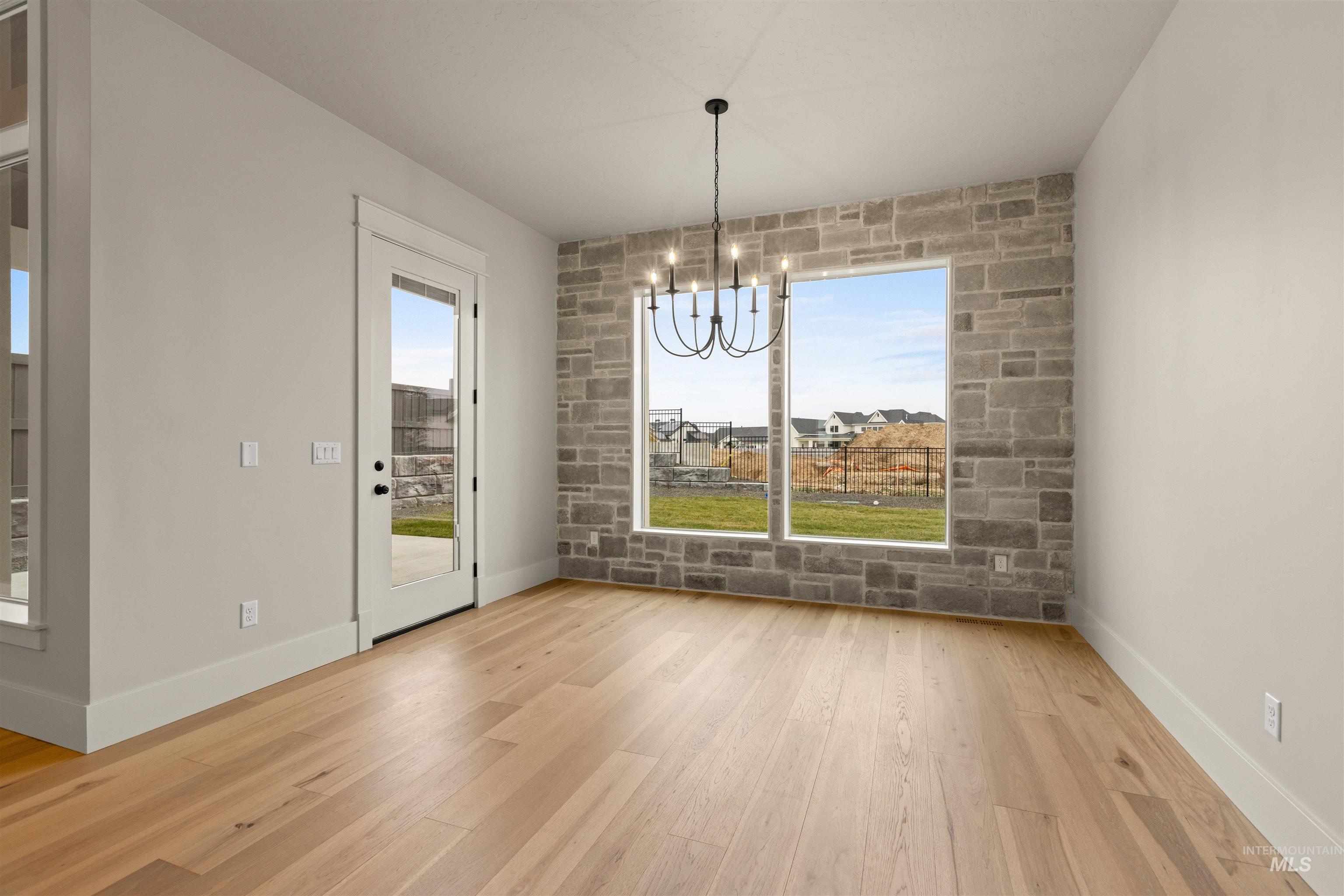 6844 South Messner Way Meridian, ID 83642 - Photo 21 of 49 Unfurnished dining area featuring a chandelier and light wood-style flooring