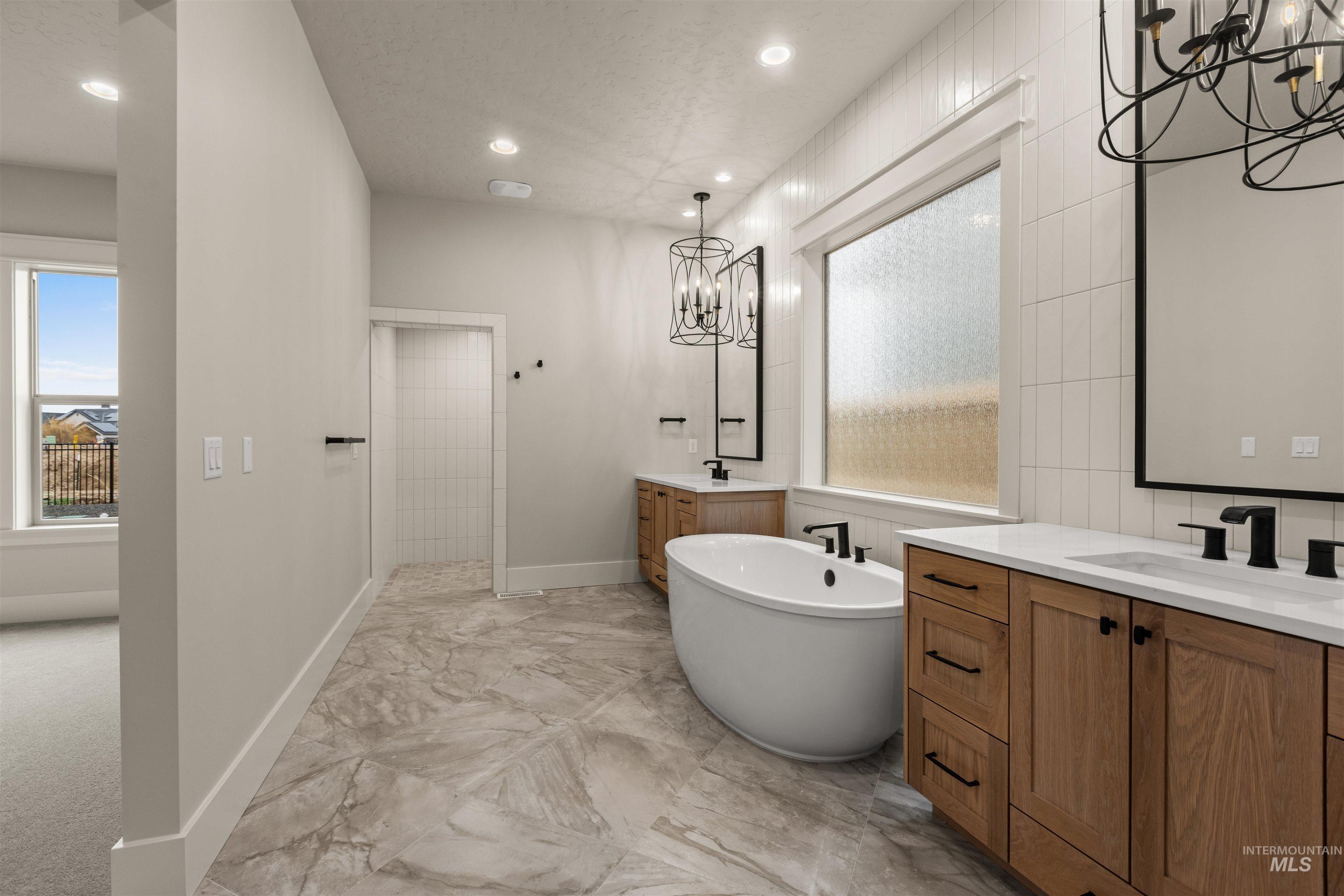 6844 South Messner Way Meridian, ID 83642 - Photo 28 of 49 Full bath featuring a chandelier, two vanities, a freestanding tub, recessed lighting, and light marble finish floors