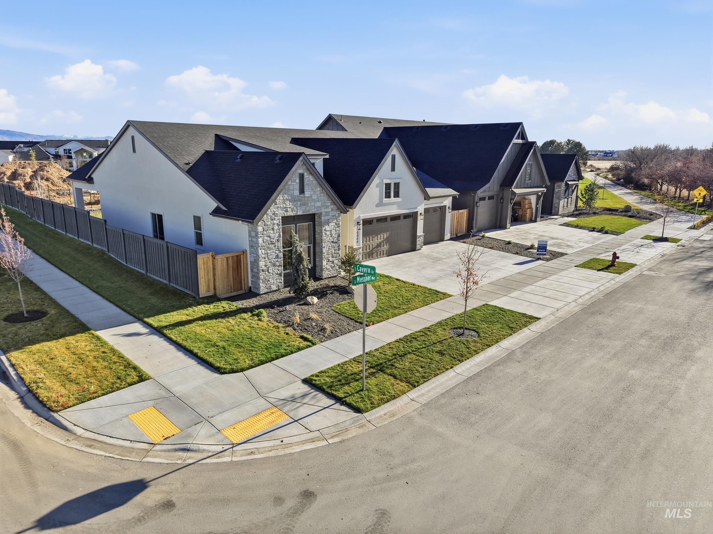 6844 South Messner Way Meridian, ID 83642 - Photo 39 of 49 View of front facade with stone siding, concrete driveway, a garage, and a residential view