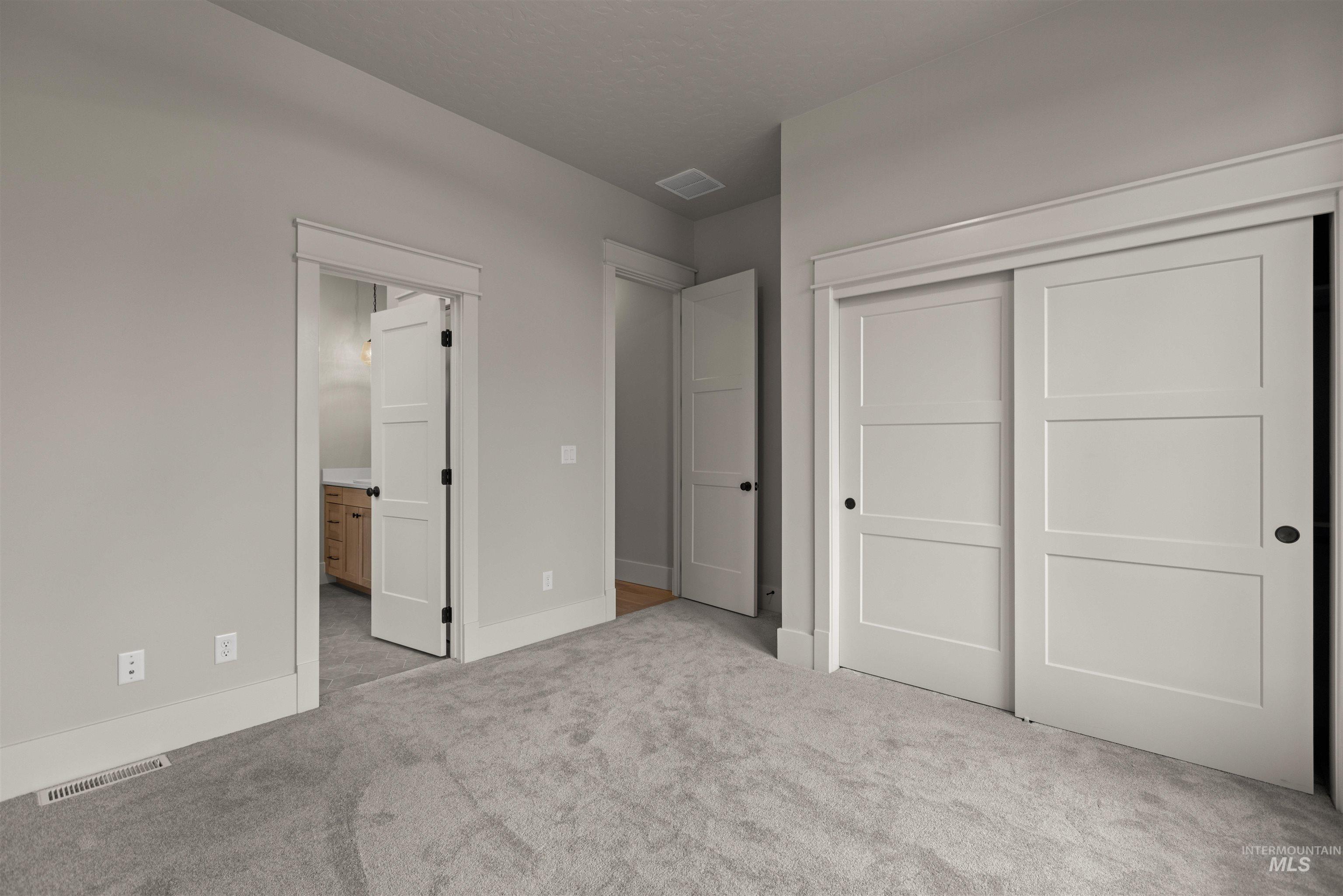 6844 South Messner Way Meridian, ID 83642 - Photo 5 of 49 Unfurnished bedroom featuring a closet, light carpet, and ensuite bathroom