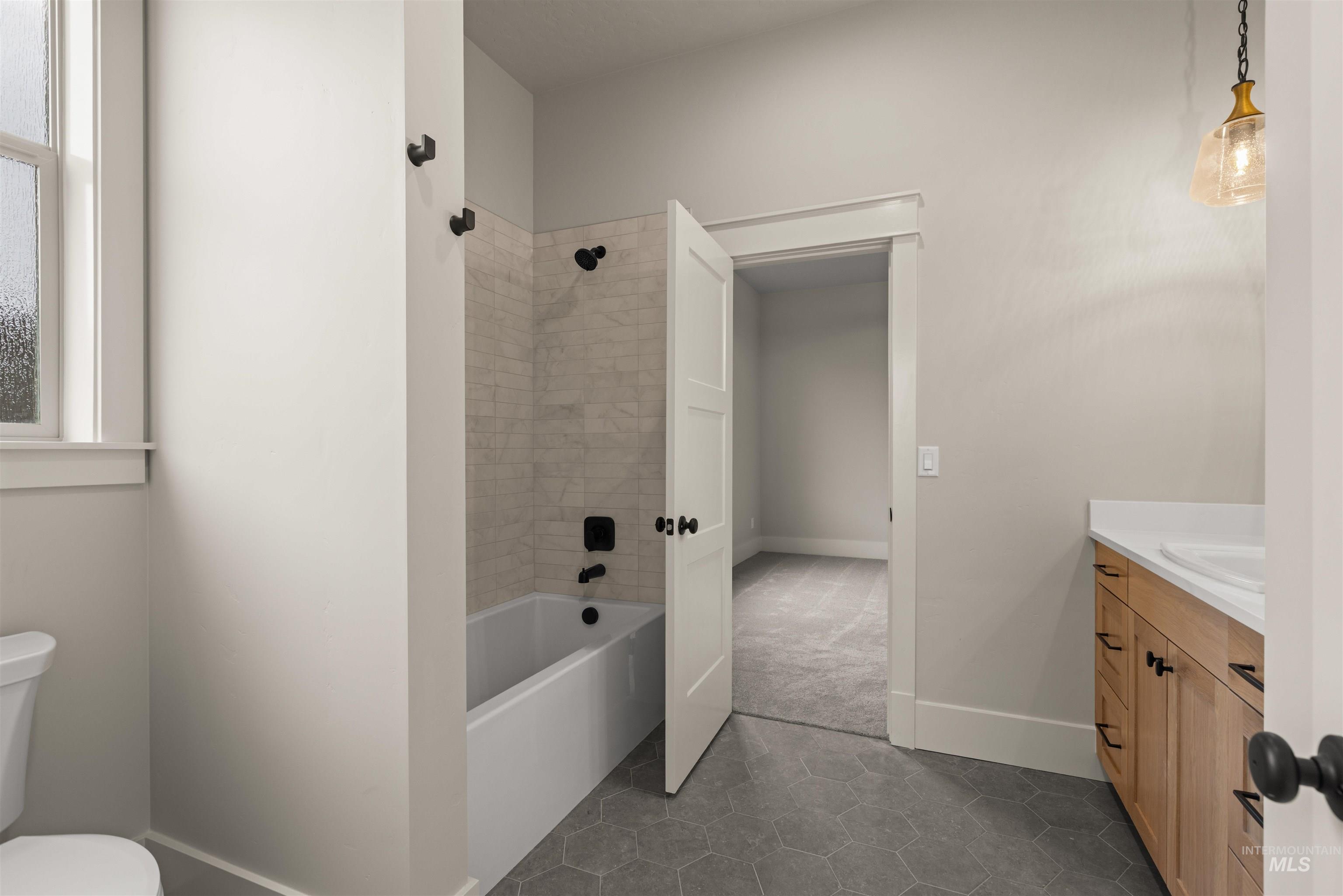 6844 South Messner Way Meridian, ID 83642 - Photo 6 of 49 Full bathroom with vanity, dark tile patterned floors, and shower / bath combination