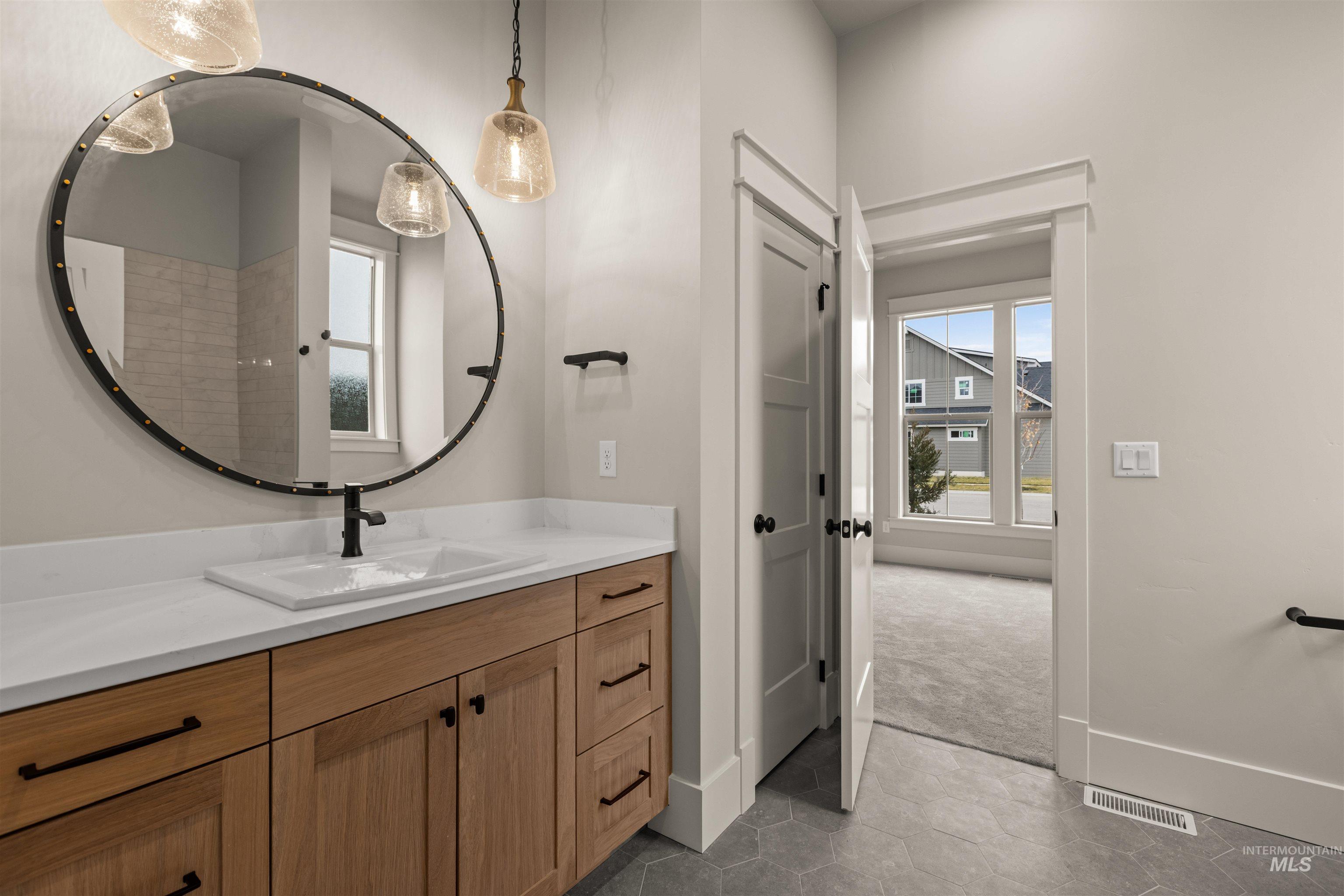 6844 South Messner Way Meridian, ID 83642 - Photo 8 of 49 Bathroom with dark tile patterned floors, plenty of natural light, and vanity
