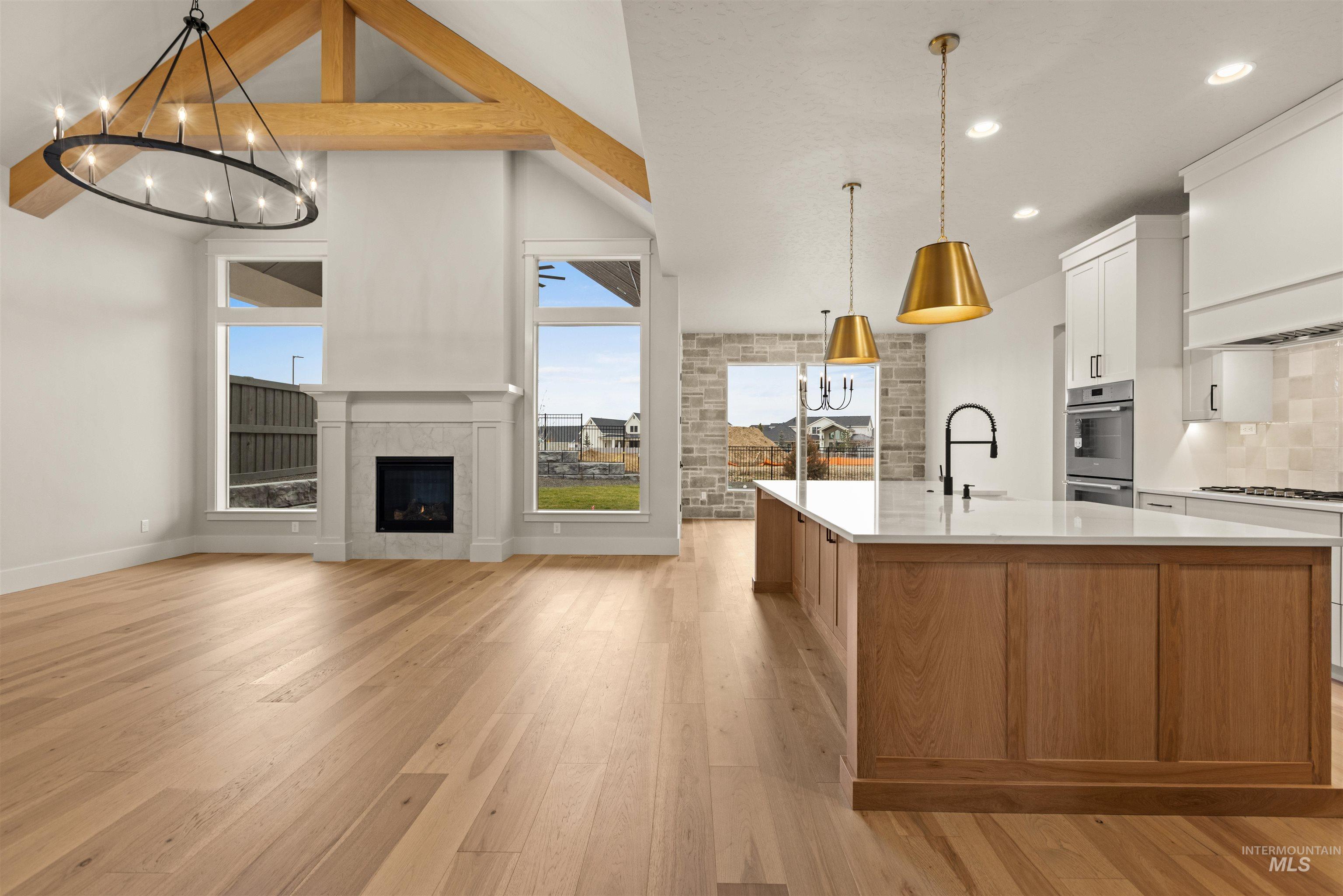 6844 South Messner Way Meridian, ID 83642 - Photo 48 of 49 Kitchen featuring white cabinetry, pendant lighting, light wood finished floors, open floor plan, and a center island with sink