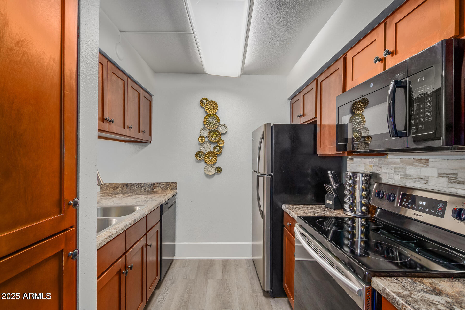7625 East Camelback Road, Unit A133 Scottsdale, AZ 85251 - Photo 11 of 26 a kitchen with stainless steel appliances granite countertop a stove and a refrigerator