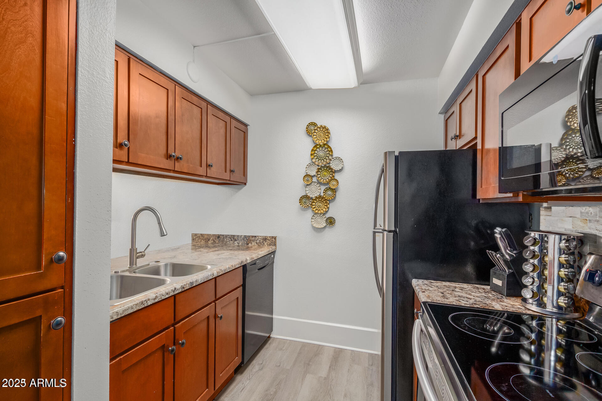 7625 East Camelback Road, Unit A133 Scottsdale, AZ 85251 - Photo 12 of 26 a kitchen with stainless steel appliances granite countertop a refrigerator and a sink