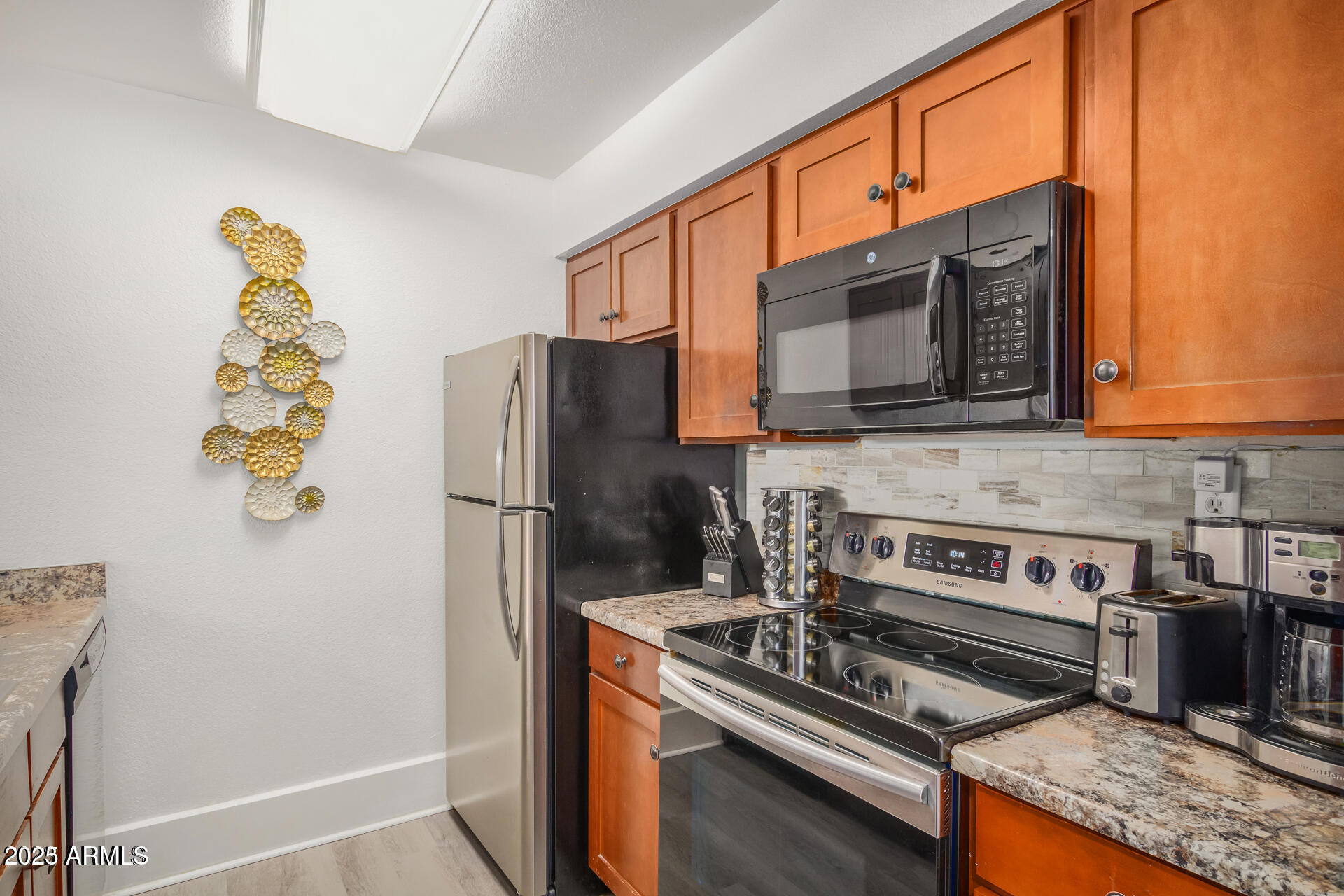 7625 East Camelback Road, Unit A133 Scottsdale, AZ 85251 - Photo 13 of 26 a kitchen with stainless steel appliances a stove a microwave and a refrigerator