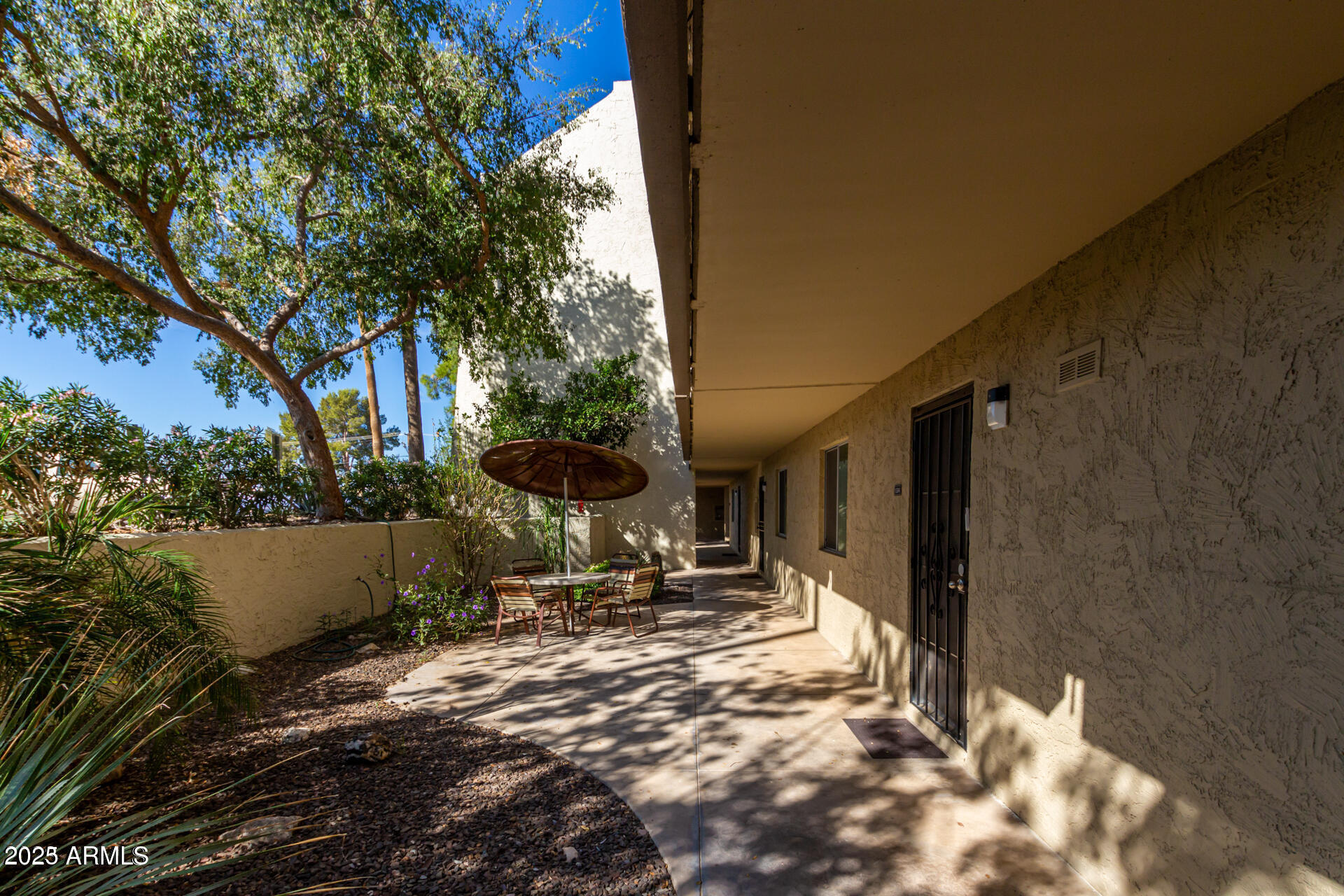 7625 East Camelback Road, Unit A133 Scottsdale, AZ 85251 - Photo 5 of 26 a backyard of a house with table and chairs