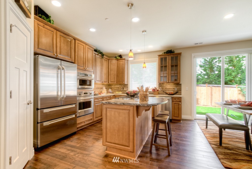 18201 41st Avenue Southeast Bothell, WA 98012 - Photo 4 of 19 a kitchen with counter top space stainless steel appliances and wooden floor