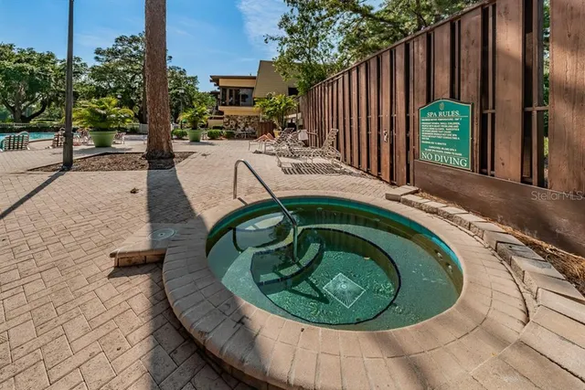 a view of a swimming pool with a patio and plants