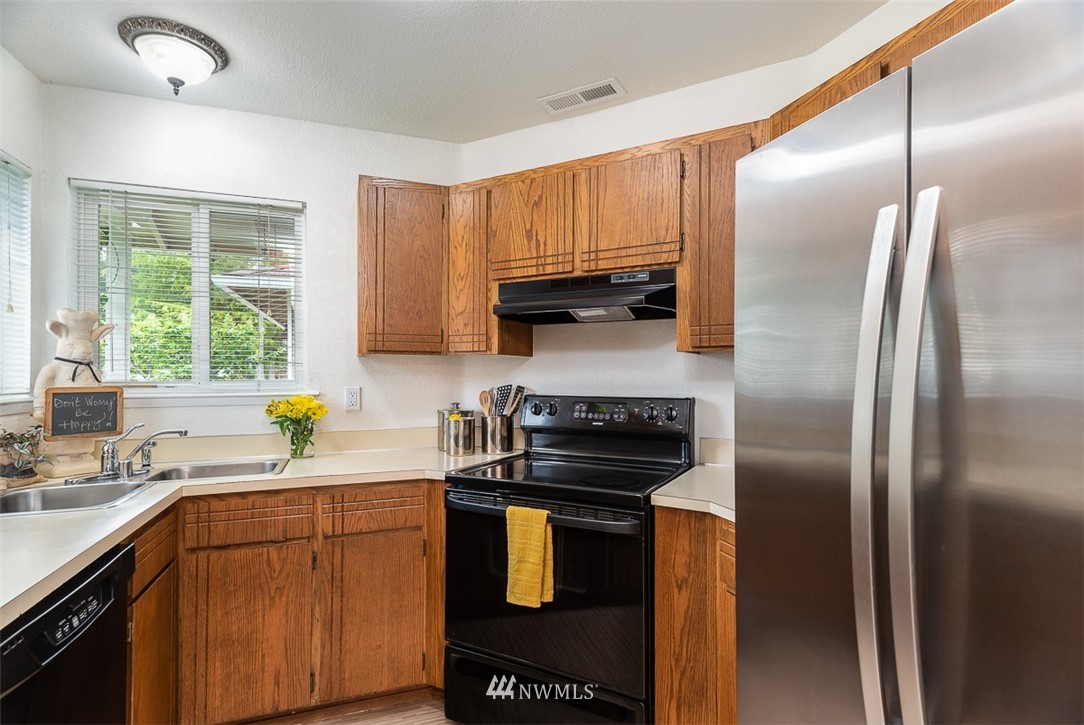 1326 232nd Place Southwest Bothell, WA 98021 - Photo 10 of 23 a kitchen with a refrigerator a sink a stove a window cabinets and stainless steel appliances