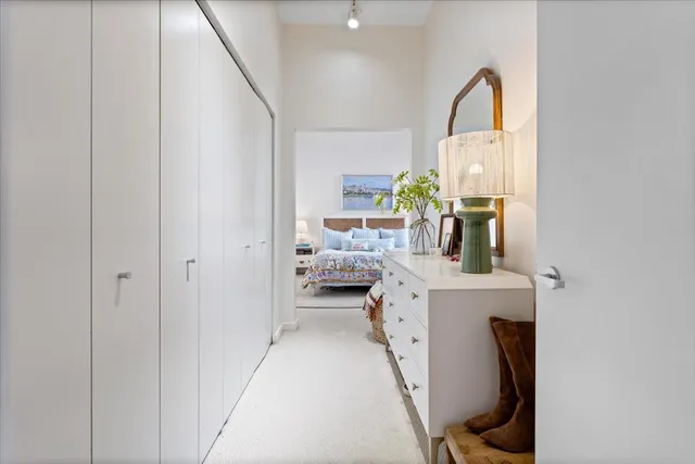 a bedroom with a bed a painting and a window