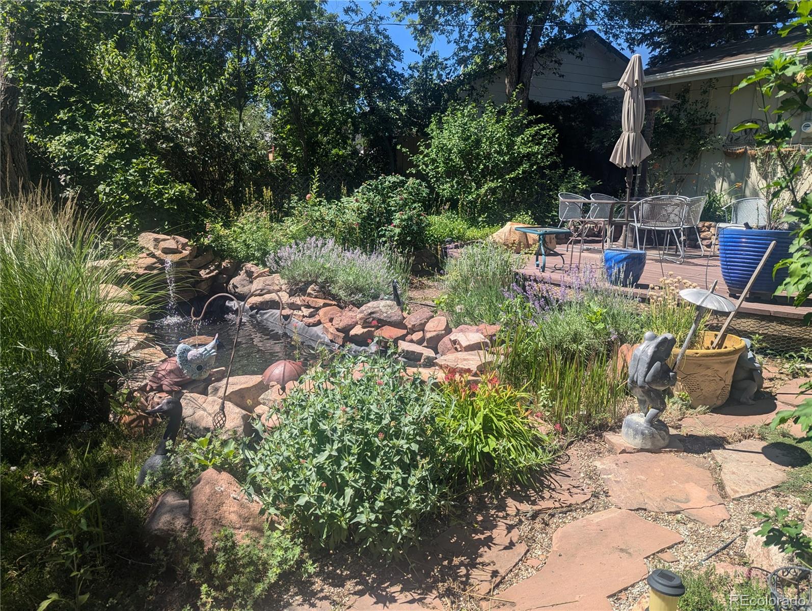 1080 Ithaca Drive Boulder, CO 80305 - Photo 12 of 35 a backyard of a house with lots of green space and fountain
