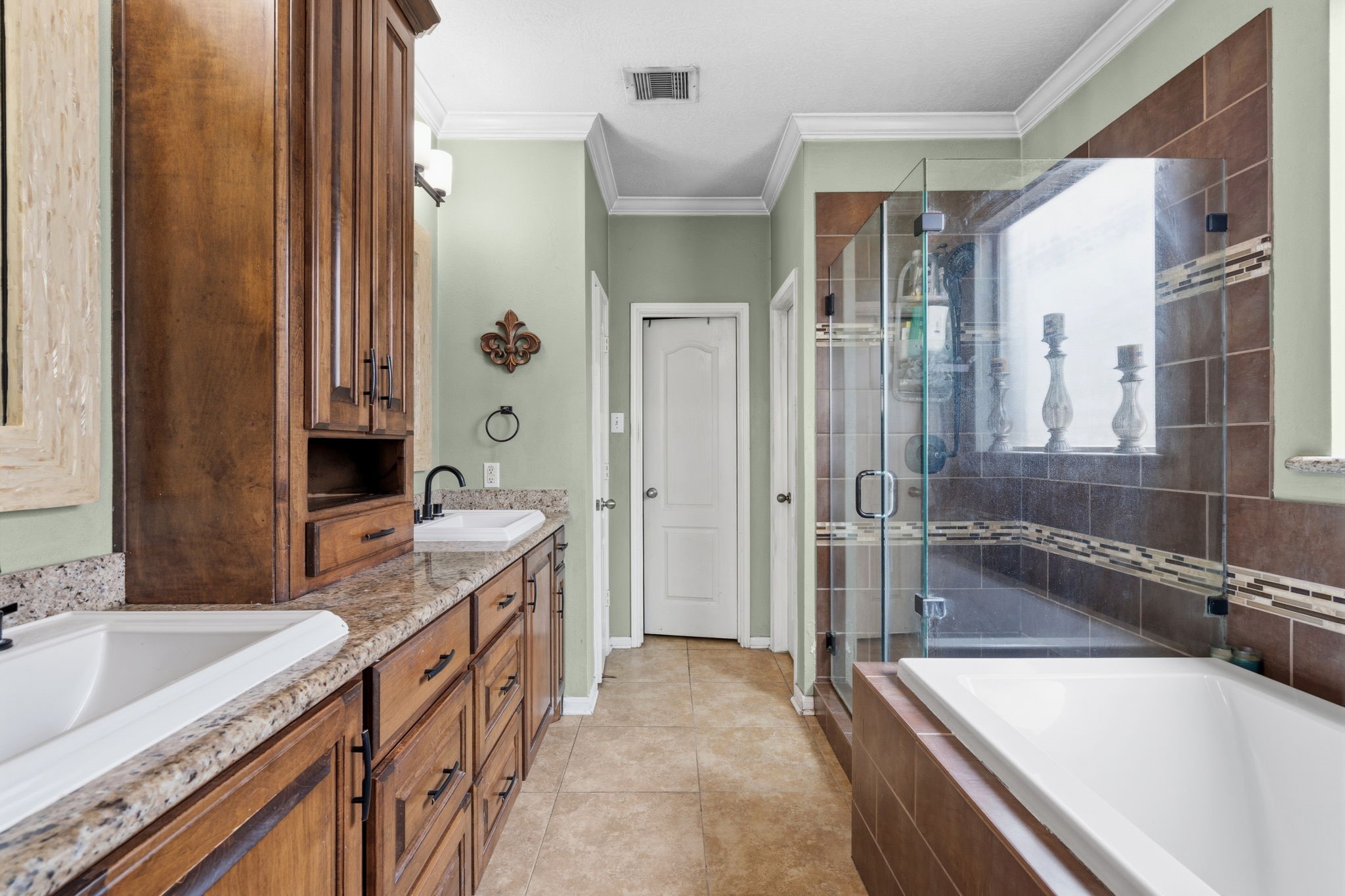 1319 Collier Point Lane Fresno, TX 77545 - Photo 18 of 33 The primary bathroom offers a spa-like retreat with dual vanities, a soaking tub, and a spacious glass-enclosed shower designed for relaxation.