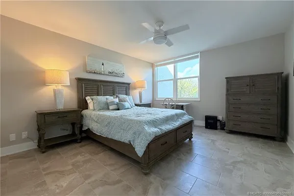 a bedroom with a bed and a ceiling fan