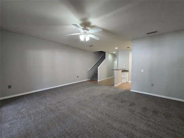 an empty room with a ceiling fan and entryway