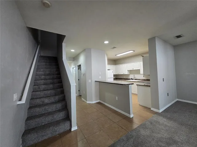 a view of kitchen with sink and refrigerator