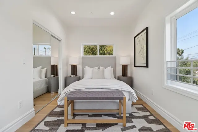 a bedroom with a bed a mirror and a desk