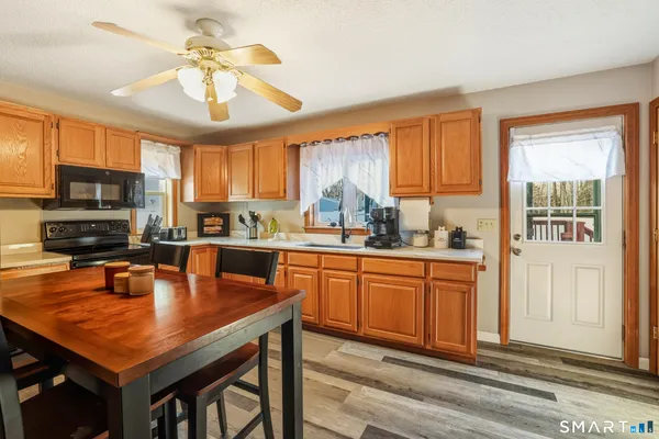 a kitchen with stainless steel appliances granite countertop a sink a stove cabinets counter space and a window