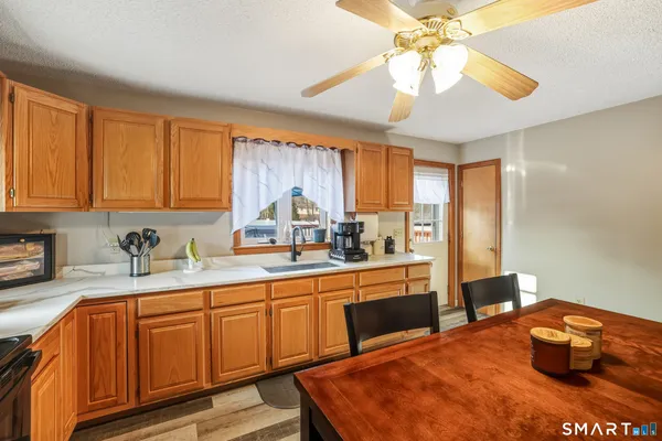 a kitchen with stainless steel appliances granite countertop a sink a stove cabinets and wooden floor